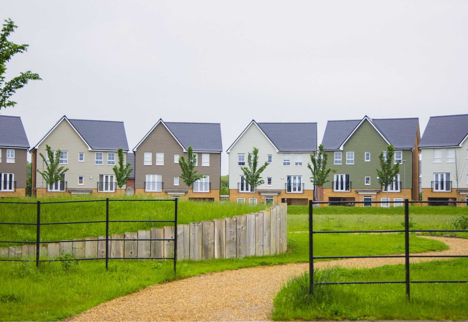 Row of new homes with grassland around them.
