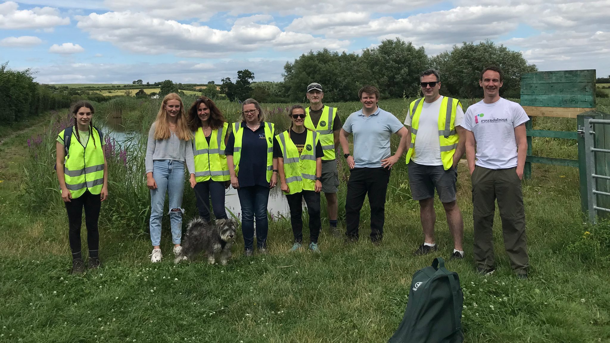 Group of volunteers lined up alongside a canal.