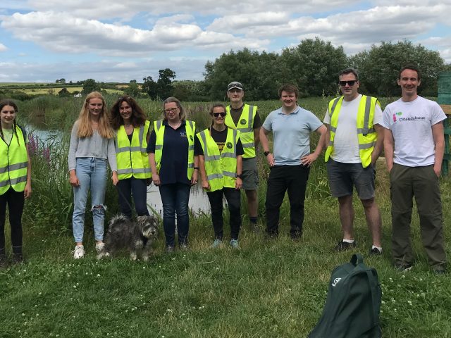Group of volunteers lined up alongside a canal.