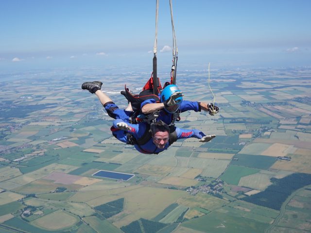 Skydivers falling just as the parachute is pulled.