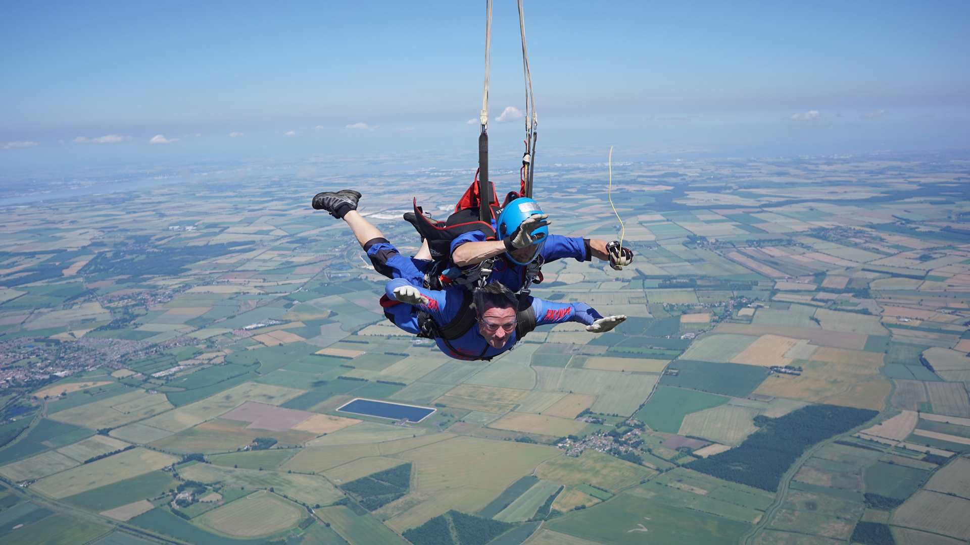 Skydivers falling just as the parachute is pulled.